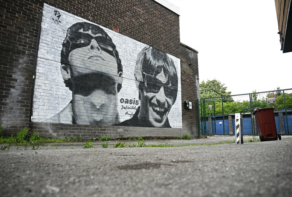 Arte de rua representando Liam e Noel Gallagher do Oasis, criada pelo artista de rua Pic.One.Art,  retratada na lateral da loja Sifters Record em Manchester (Foto: PAUL ELLIS / AFP)