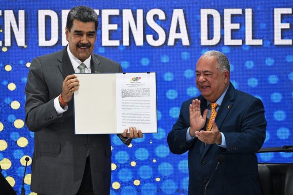 Nicols Maduro (E) mostra a ata com o resultado da consulta popular de domingo, aplaudido pelo presidente do Conselho Nacional Eleitoral, Elvis Amoroso 
 (Crdito: Federico Parra/AFP)