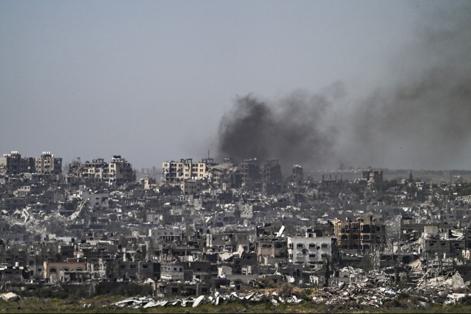 Esta foto tirada da fronteira sul de Israel com a Faixa de Gaza mostra fumaa subindo atrs de edifcios destrudos 
 (Crdito: RONALDO SCHEMIDT / AFP)