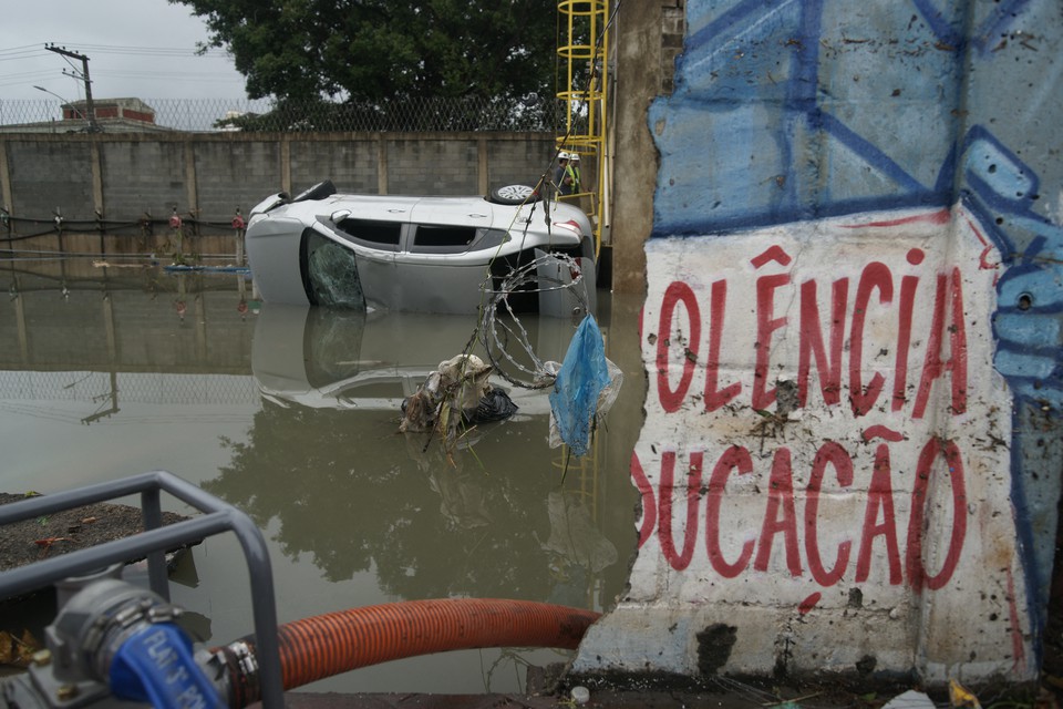 Carro que foi arrastado para a linha frrea inundada da estao Acari do metr aps fortes chuvas causarem destruio no subrbio do Rio de Janeiro (Crdito: BRUNO KAIUCA / AFP)