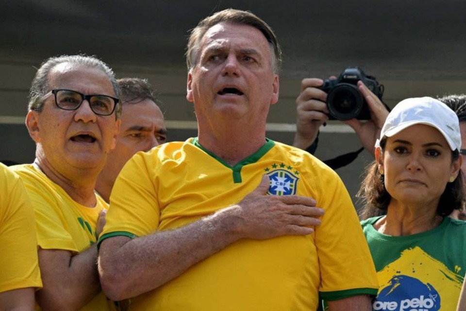 
O ex-presidente brasileiro Jair Bolsonaro (C) canta o hino nacional ao lado de sua esposa Michelle Bolsonaro (R) e do pastor Silas Malafaia (L) durante um comcio em So Paulo  (foto: NELSON ALMEIDA / AFP)