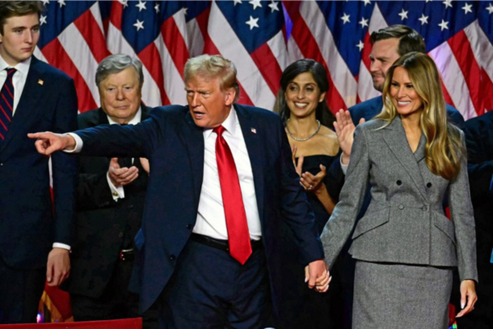 O ex-presidente dos EUA e candidato presidencial republicano Donald Trump e a ex-primeira-dama dos EUA Melania Trump sorriem depois de falar durante um evento eleitoral noturno em West Palm Beach (Crdito: Jim WATSON / AFP)