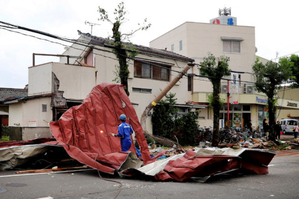 Um trabalhador remove os destroos levados pelos fortes ventos causados %u200B%u200Bpelo tufo Shanshan em Miyazaki (Crdito: STR / JIJI PRESS / AFP)