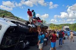 Carreta levando cerveja tomba na BR-101, no Cabo, e carga  saqueada (Foto: Reproduo das redes sociais)