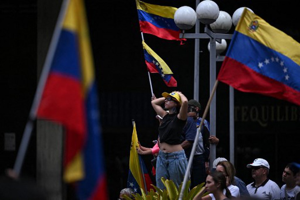 Mulher participa de comcio convocado pelo candidato presidencial Edmundo Gonzalez Urrutia e pela lder da oposio Maria Corina Machado, em frente  sede das Naes Unidas em Caracas (Foto: JUAN BARRETO / AFP
)