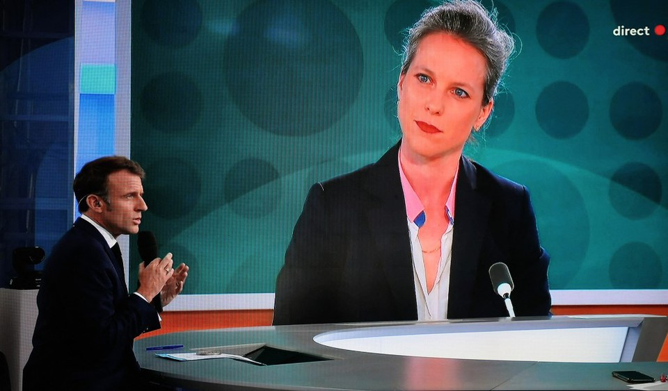 Presidente da Frana, Emmanuel Macron, dando uma entrevista ao vivo enquanto um retrato de Lucie Castets  exibido em uma tela gigante (Foto: LUDOVIC MARIN / AFP
)