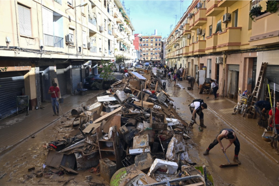 Detritos so empilhados ao longo de uma rua (Crdito: JOSE JORDAN / AFP)