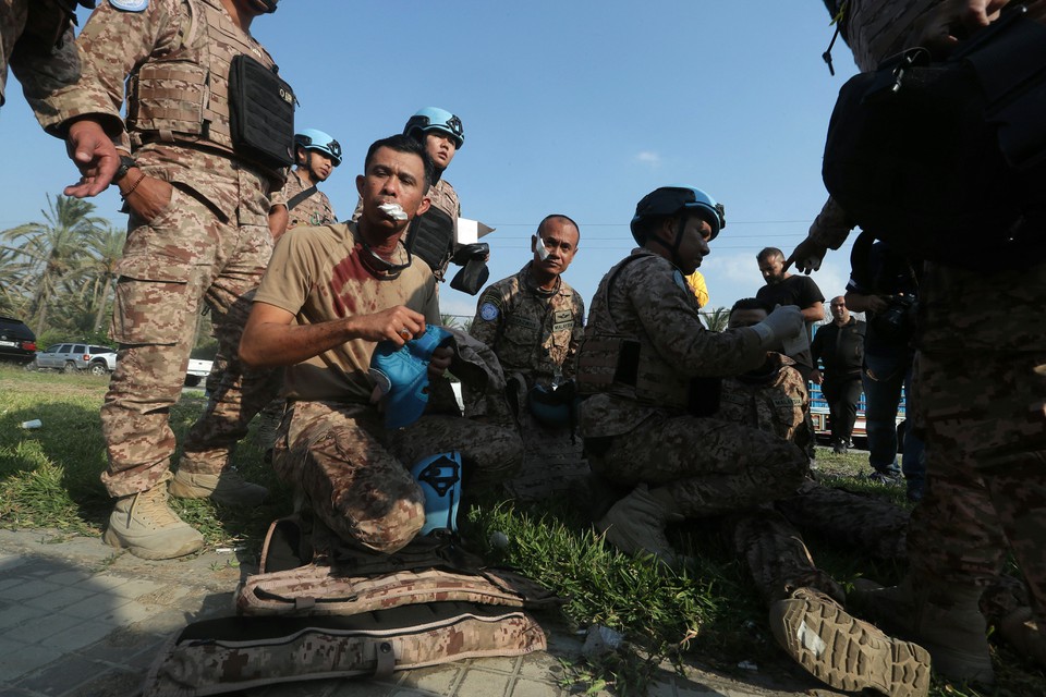 Membro ferido do batalho malaio da UNIFIL senta-se no cho depois de ter sido ferido no local de um ataque areo israelense na entrada norte da cidade de Sidon (Foto: MAHMOUD ZAYYAT / AFP)