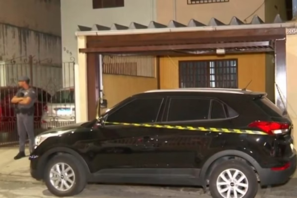 Policiais na frente da casa de adolescente que confessou ter matado a tiros os pais adotivos e a irm em SP (Crdito: Reproduo / TV Globo)