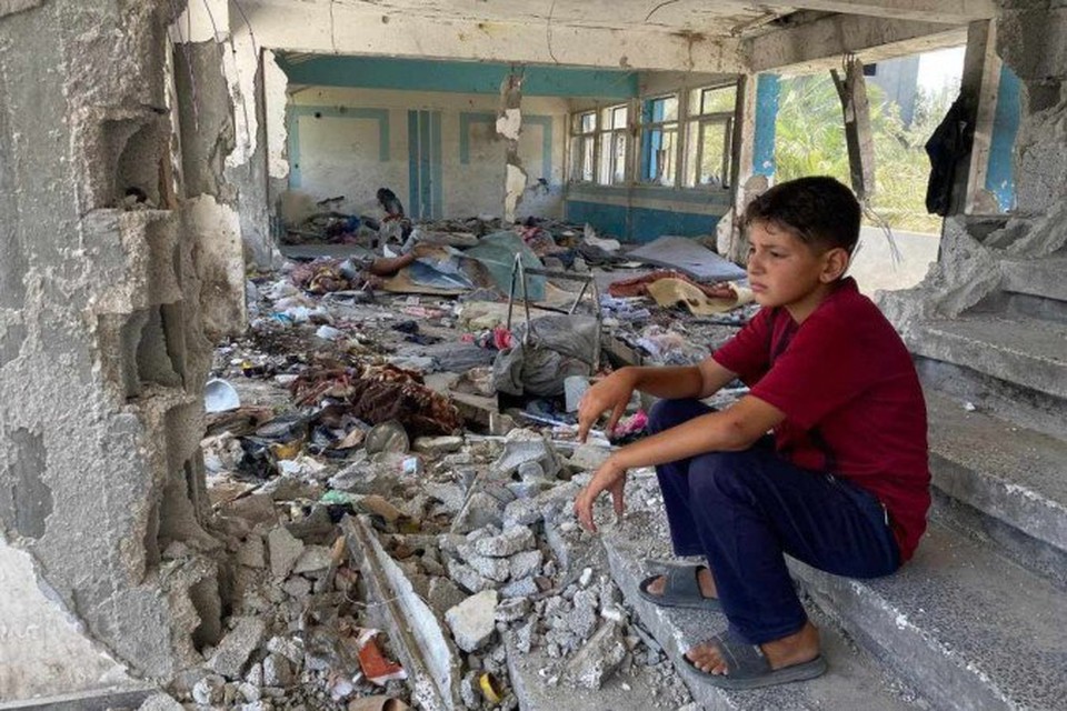 
Menino sentado nos escombros de uma escola destruda da UNRWA em Nuseirat, rea central da Faixa de Gaza (foto: Reproduzido com permisso da UNRWA)