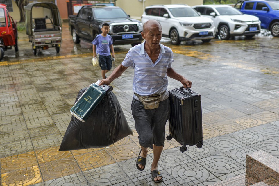 Residente local carrega comida e sua bagagem para um abrigo temporrio em uma escola primria antes da esperada chegada do Supertufo Yagi (Foto: STR / CNS / AFP)