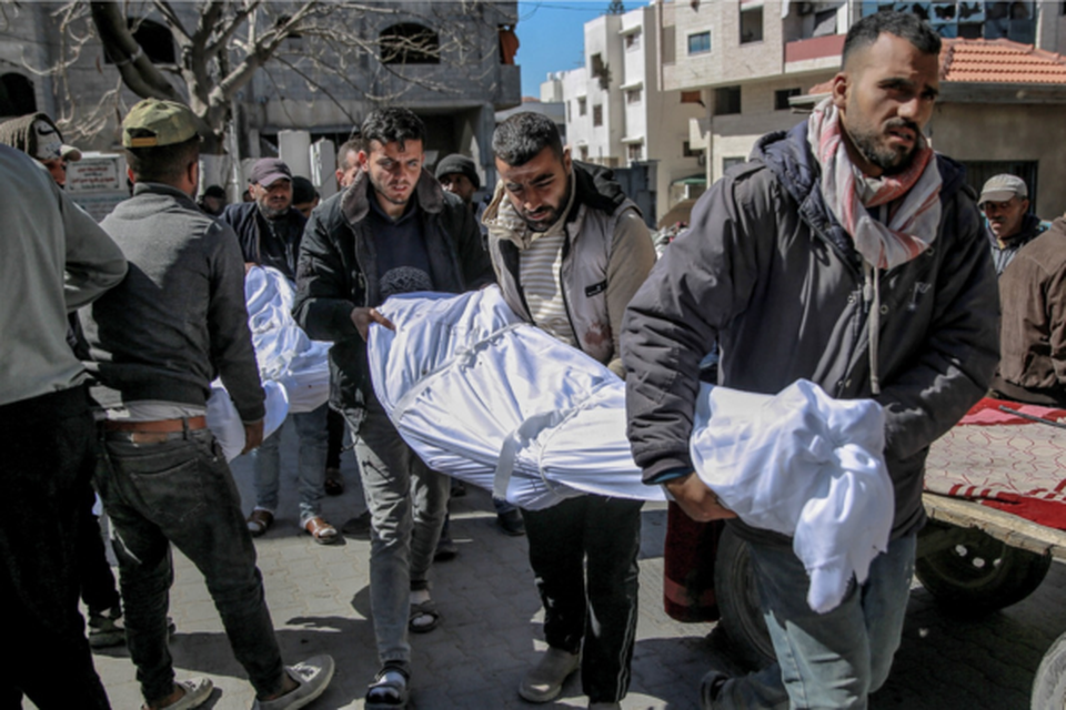 Um homem palestino chora pelo corpo de um parente morto durante o bombardeio israelense noturno (Crdito: AFP)