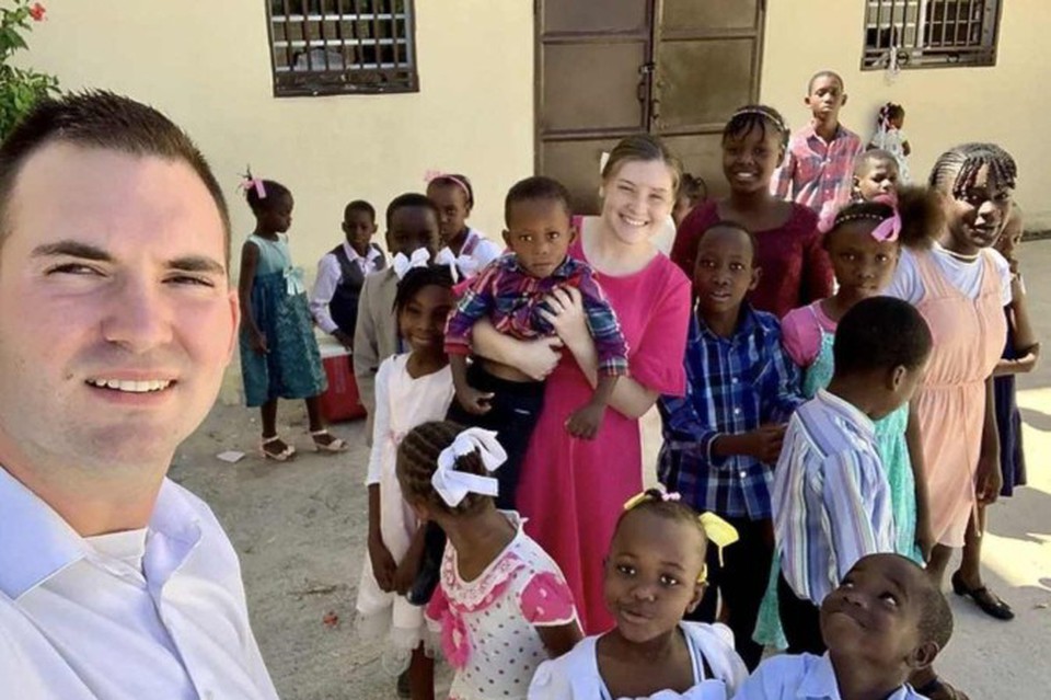 Os missionrios norte-americanos Davy e Natalie Lloyd posando com crianas haitianas (MISSIONS IN HAITI / AFP)