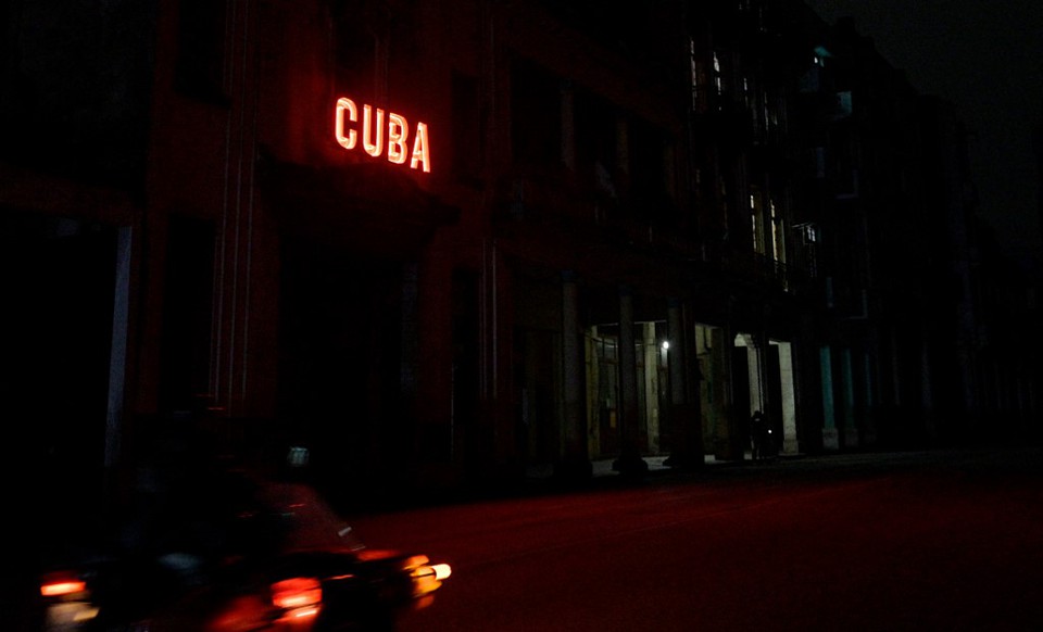 Uma placa ilumina uma rua escurecida durante o segundo dia do apago nacional em Havana (Foto: ADALBERTO ROQUE / AFP)