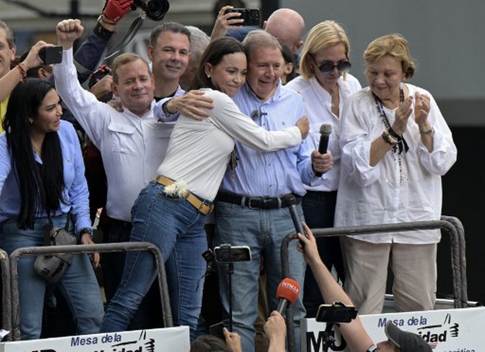 Lder da oposio venezuelana Maria Corina Machado abraa o candidato presidencial da oposio Edmundo Gonzalez Urrutia durante um comcio em frente  sede das Naes Unidas em Caracas (Foto: YURI CORTEZ / AFP
)