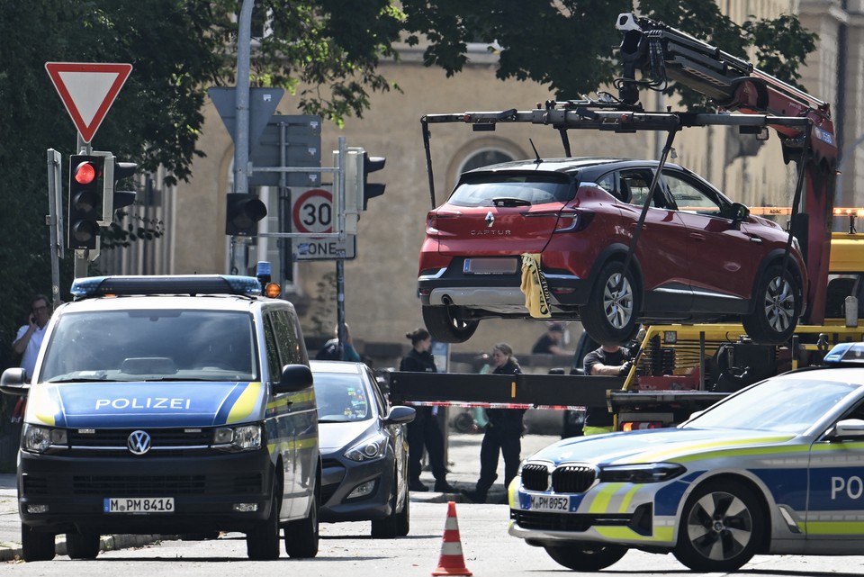 Policiais removem um carro com placa austraca com um guindaste enquanto protegem a rea aps um tiroteio perto do consulado israelense (Foto: LUKAS BARTH-TUTTAS / AFP)