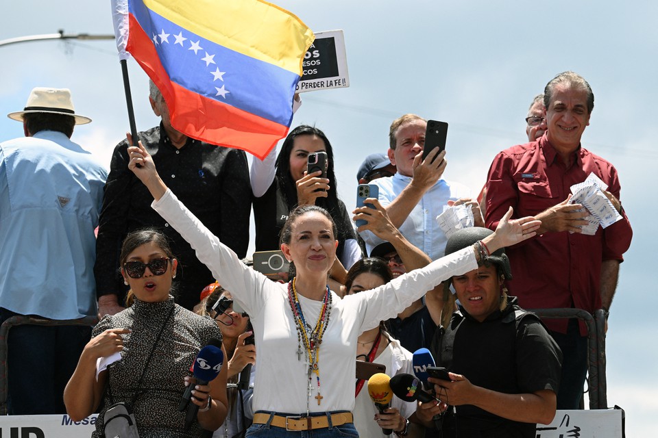 Lder da oposio venezuelana Maria Corina Machado segura uma bandeira nacional em cima de um caminho durante um protesto convocado pela oposio (Foto: FEDERICO PARRA / AFP
)