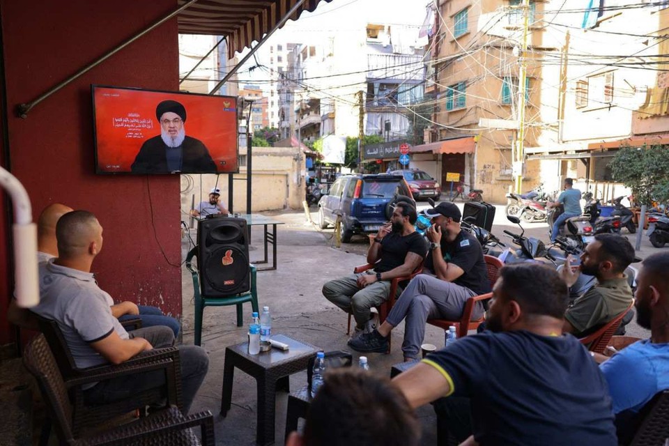 Moradores do bairro de Shiyah, no sul de Beirute, assistem ao discurso de Hassan Nasrallah em cafeteria (Crdito:  Anwar Amro/AFP)