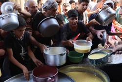 Palestinos deslocados fazem fila para receber raes alimentares, oferecidas por uma instituio de caridade, no campo de refugiados de Al-Shati, em Gaza