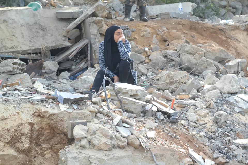 Mulher sentada sobre os escombros no local de um ataque israelense noturno em Ain Yaacoub, regio de Akkar, no Lbano (Foto: Fathi AL-MASRI / AFP)