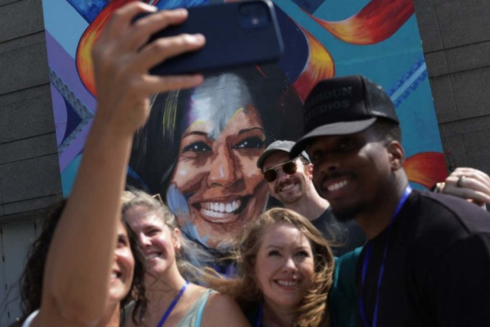 Simpatizantes de Kamala Harris fazem selfie diante de mural no United Center, local da Conveno Democrata, em Chicago  (Crdito: Alex Wong/Getty Images/AFP)