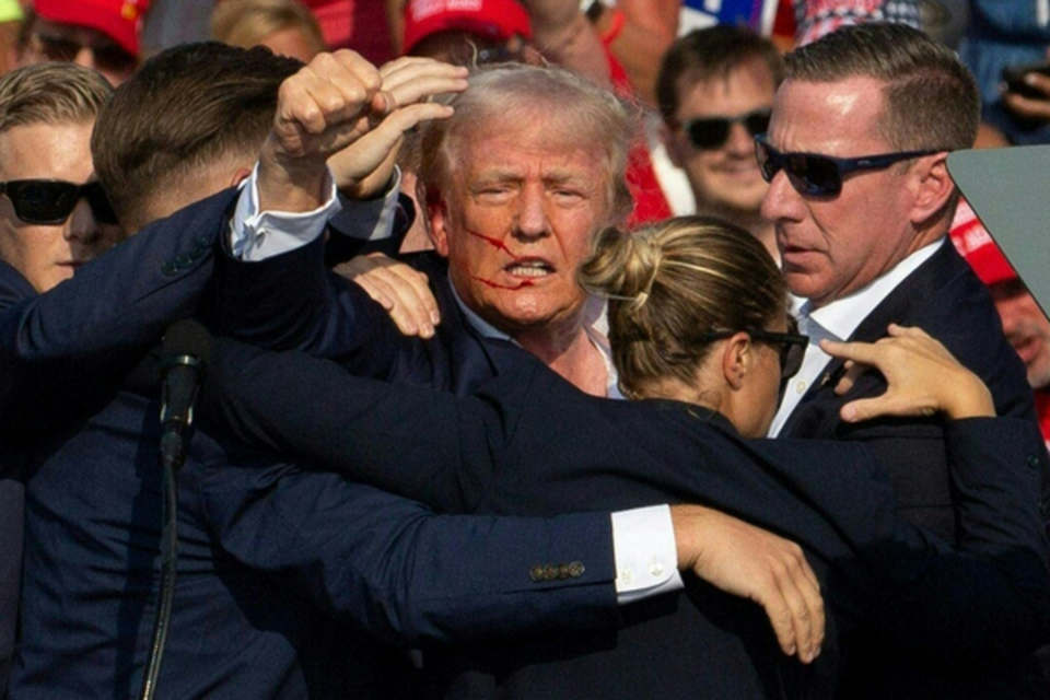 Trump acenando para os seus apoiadores aps ter sofrido um atentado (Crdito: REBECCA DROKE / AFP)