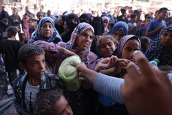 Palestinos esperam em fila para receber po em frente a uma padaria em Khan Yunis, no sul da Faixa de Gaza