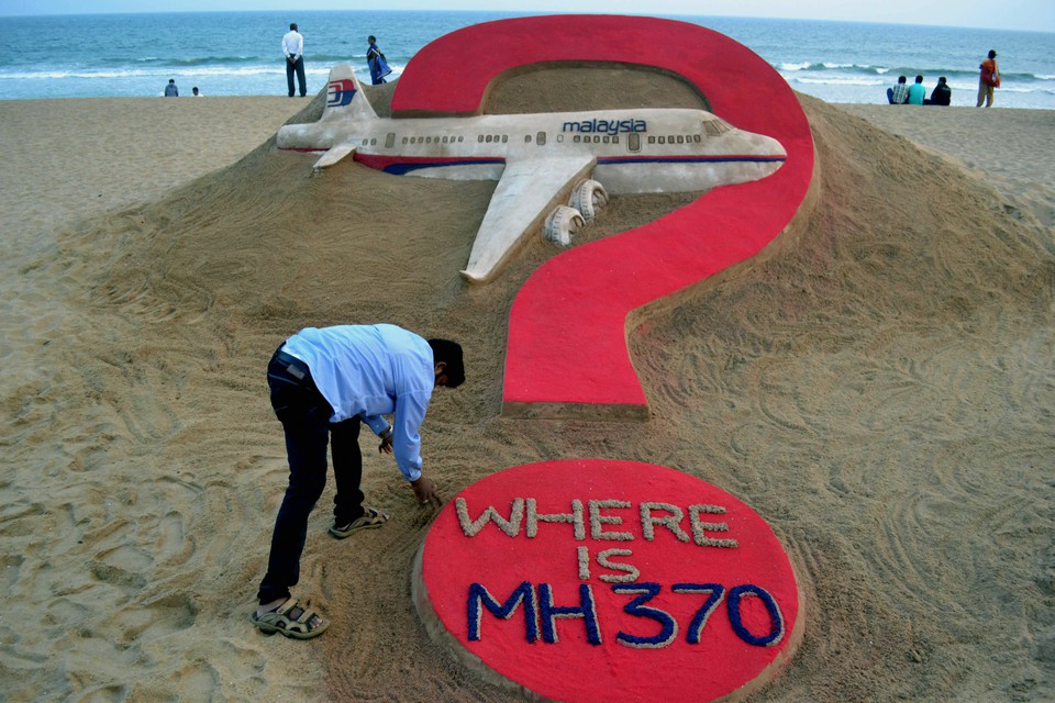 O artista de areia indiano Sudarsan Pattnaik cria uma escultura de areia do voo MH370 da Malaysia Airlines desaparecido na praia de Puri, no leste do estado de Odisha, em 7 de maro de 2015  (Crdito: J .K. JAGDEV / AFP)