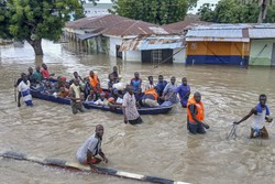 Pessoas afetadas pelas enchentes so escoltadas pelas enchentes em um barco militar em Maiduguri