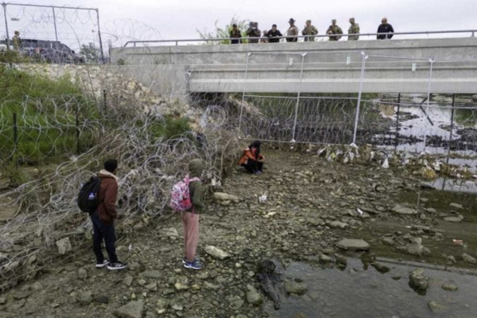 Em Eagle Pass, no Texas, soldados e policiais observam imigrantes que cruzaram o Rio Grande para tentar entrar nos EUA  (Crdito: Getty Images via AFP
)