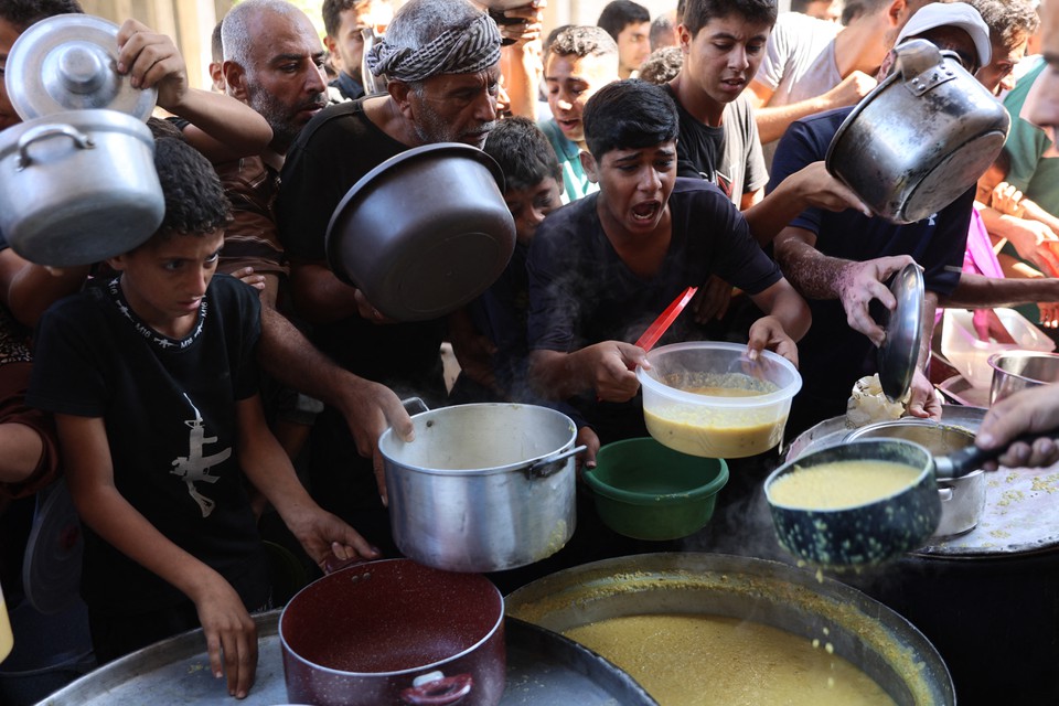 Palestinos deslocados fazem fila para receber raes alimentares, oferecidas por uma instituio de caridade, no campo de refugiados de Al-Shati, em Gaza (Foto: Omar AL-QATTAA / AFP)