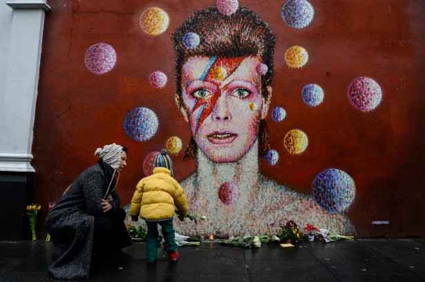 Homenagens so deixados sob um mural de cantor britnico David Bowie, pintado pelo artista australiano, em Londres. Foto: Chris Ratcliffe/AFP