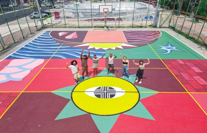 Pessoas jogando basquete em quadra poliesportiva pública na orla