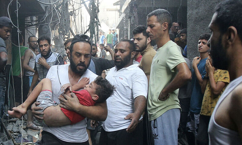 

Um homem carrega uma menina ferida aps um ataque israelense a um campo de refugiados, no centro da Faixa de Gaza  (

foto: BASHAR TALEB/AFP
)